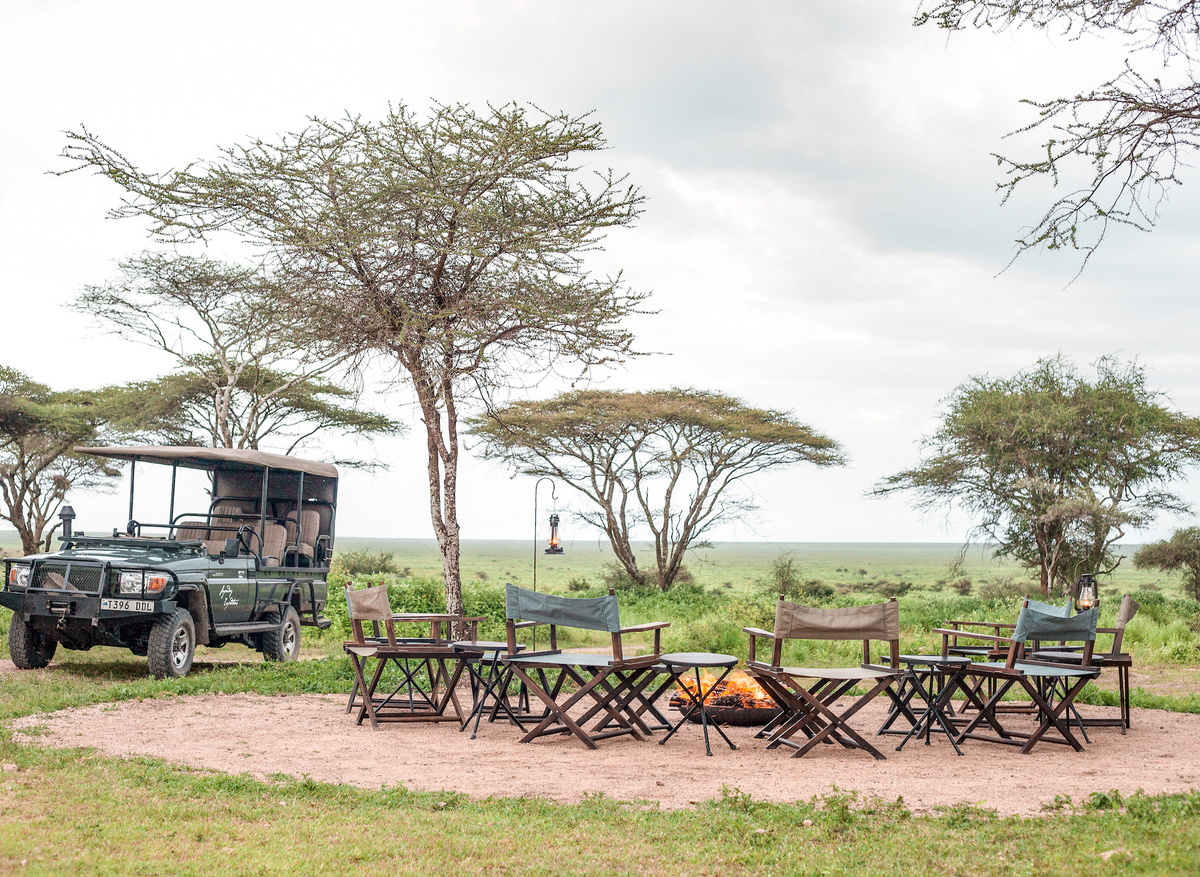 Nyasi Migrational Camp - campfire and safari vehicle.jpeg