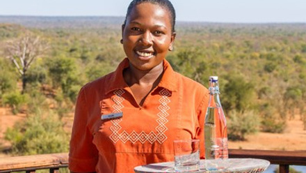 Victoria Falls Safari Lodge waitress Kudakwashe Ruwuya serves water in a re-useable glass bottle.jpg
