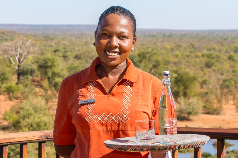 B1E4-victoria-falls-safari-lodge-waitress-kudakwashe-ruwuya-serves-water-in-a-re-useable-glass-bottle.jpg