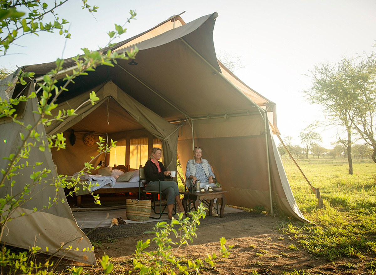 Enjoying coffee on the verandah of their tent at Pembezoni Camp